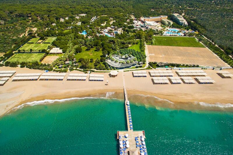 Blue Waters Club von oben über die Gesamtanlage mit Pools, Pinien und Strand