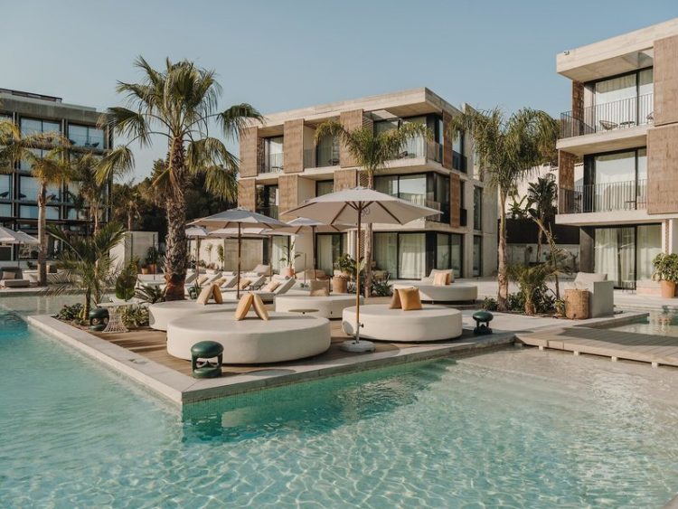 Pool im Hintergrund Liegeinseln und das Hotelgebäude