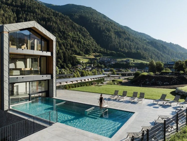 Aussenpool im Hintergrund das Hotel und die Berge