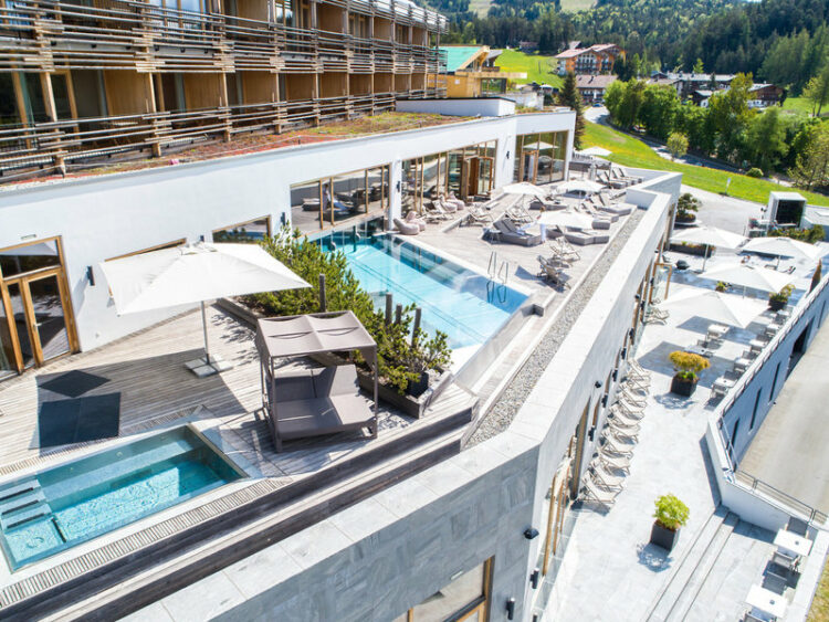 Bick auf den Aussenpool im Hintergrund das Hotellgebäude