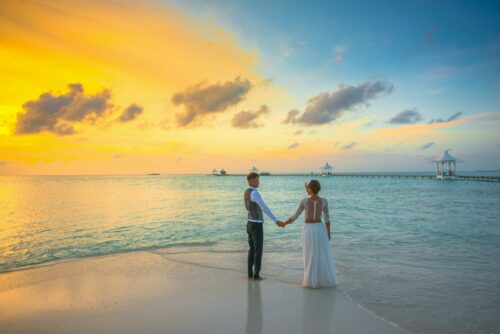 Hochzeitsreise Paar am Strand beim Sonnenuntergang