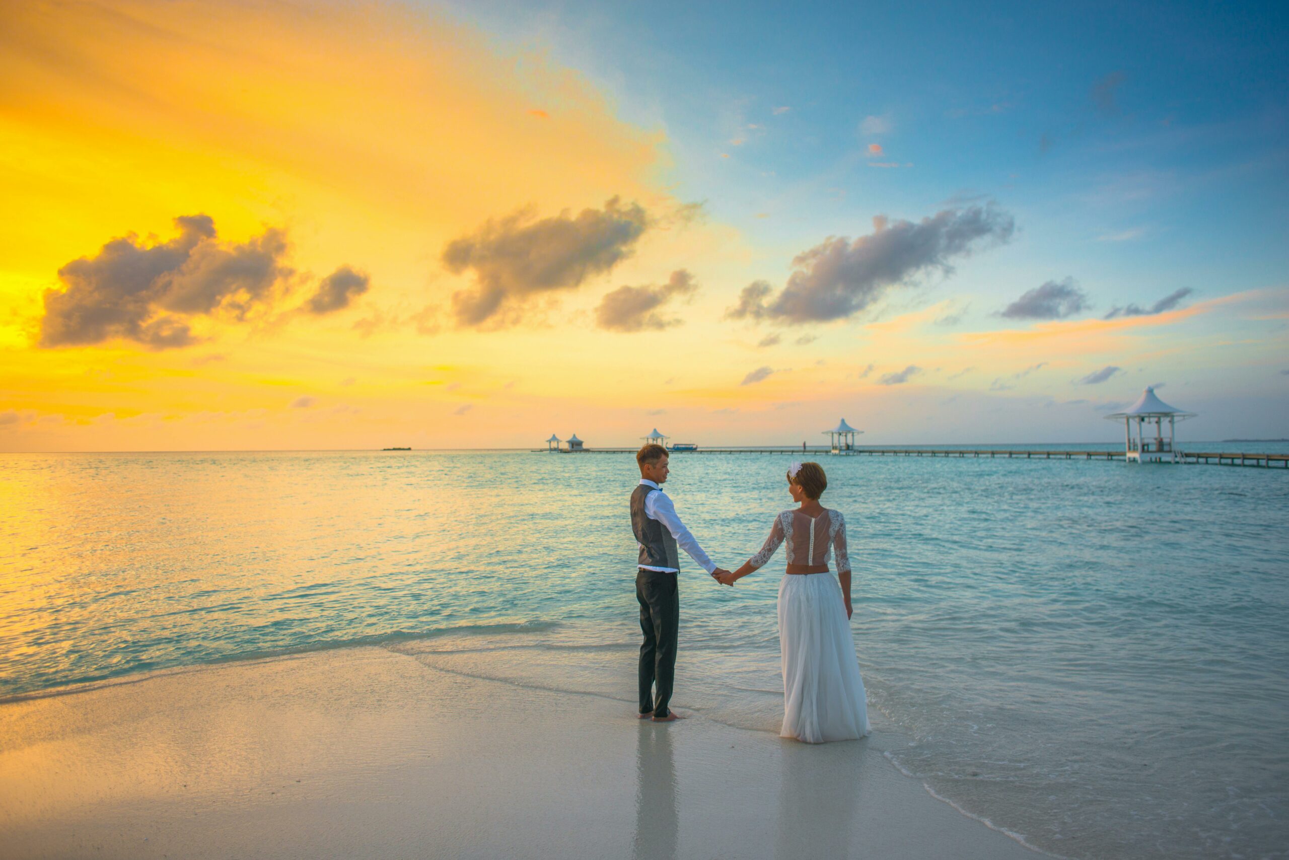 Hochzeitsreise Paar am Strand beim Sonnenuntergang