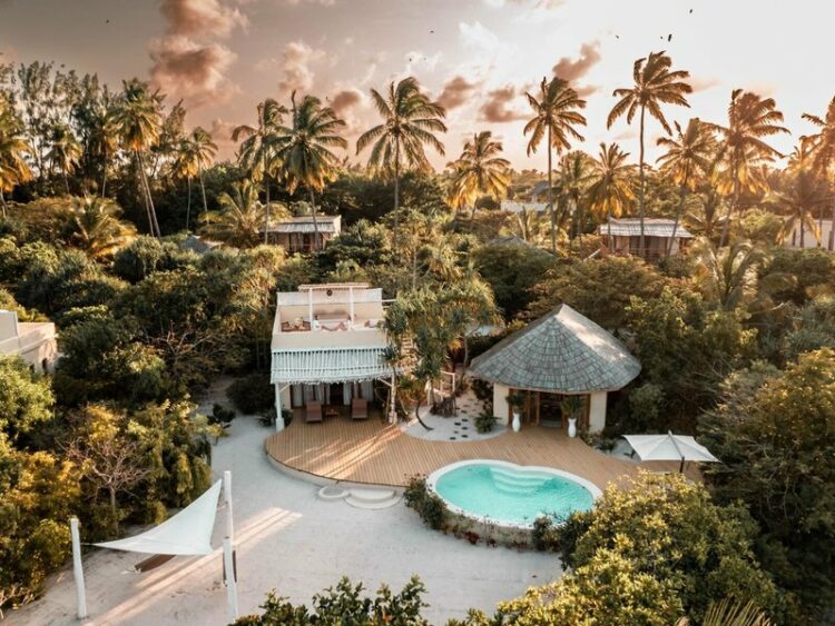 Blick von oben auf einen Bungalow mit privatem Pool Palmen und weißer Sandstrand