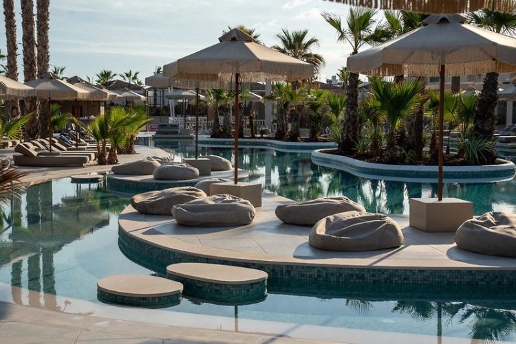 Blick auf die Poolanlage mit Liegen und dicken barunen Matten